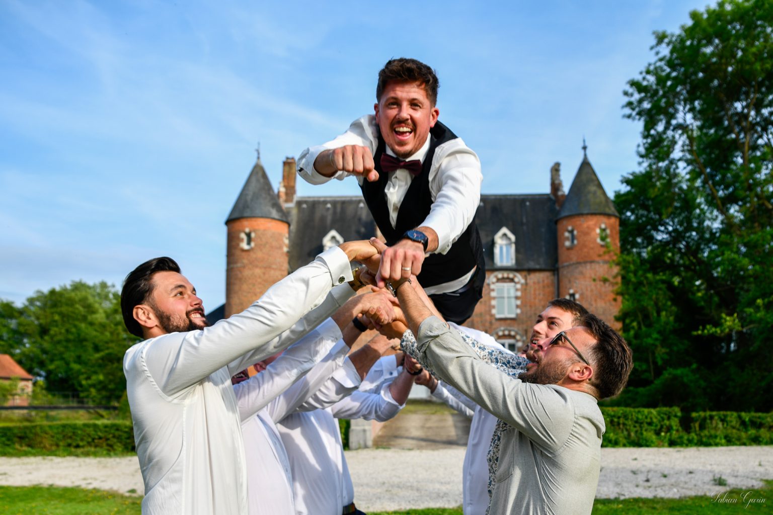 Photographe de mariage à Renescure – Les mariés portés par leurs amis au château de Zuthove, le 31 mai 2025