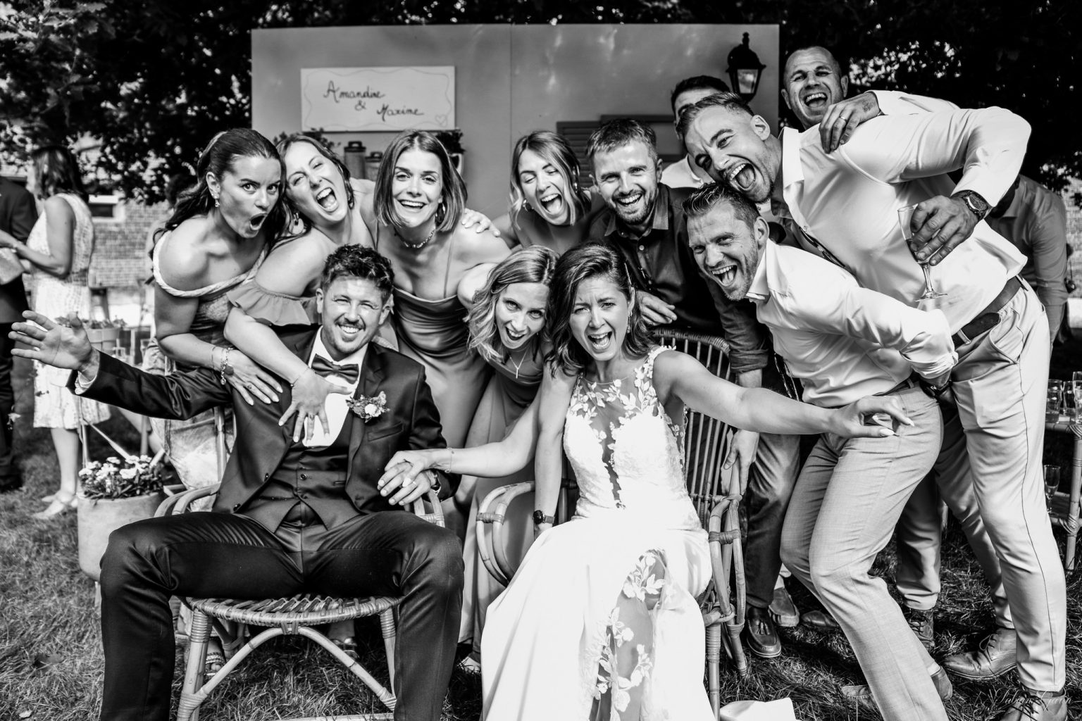 Photographe de mariage à Renescure – Les mariés portés par leurs amis en noir et blanc au château de Zuthove, le 31 mai 2025.