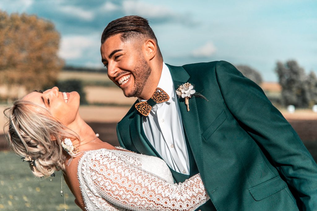 Marine et Madani échangent un regard complice et éclatent de rire lors de leur mariage au Domaine Les Hauts de Vertigneul, dans une ambiance joyeuse et lumineuse.