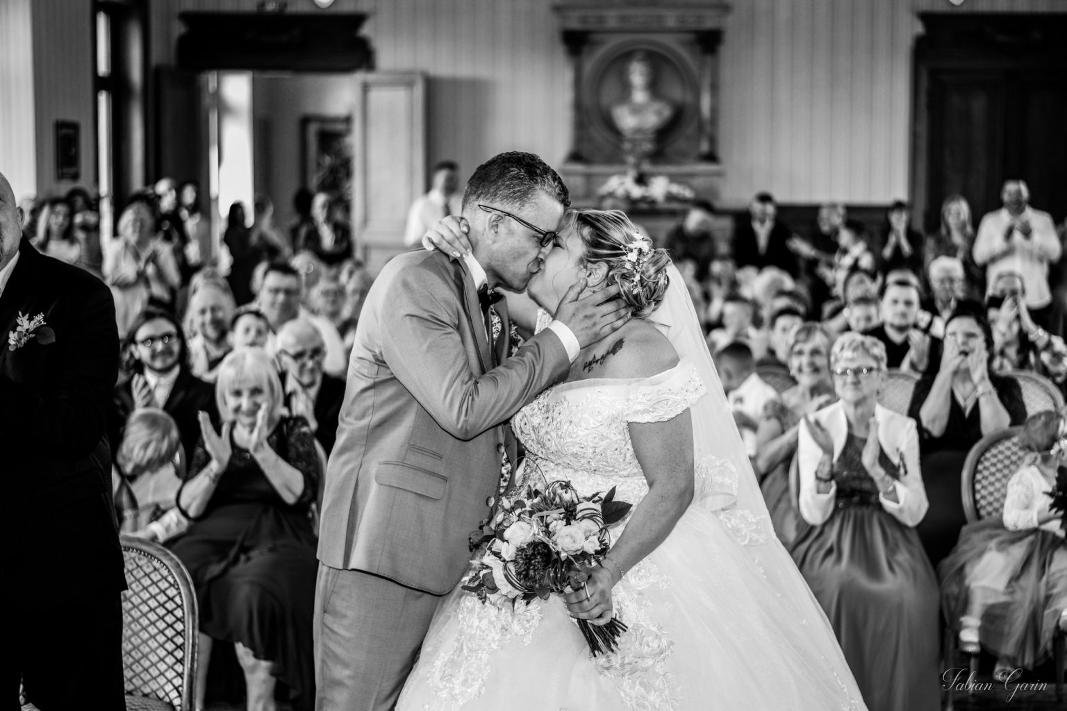 Julianna et Meadi s’embrassent juste après s’être dit "oui", entourés de leurs invités émus et applaudissants, lors de leur cérémonie de mariage à la mairie.