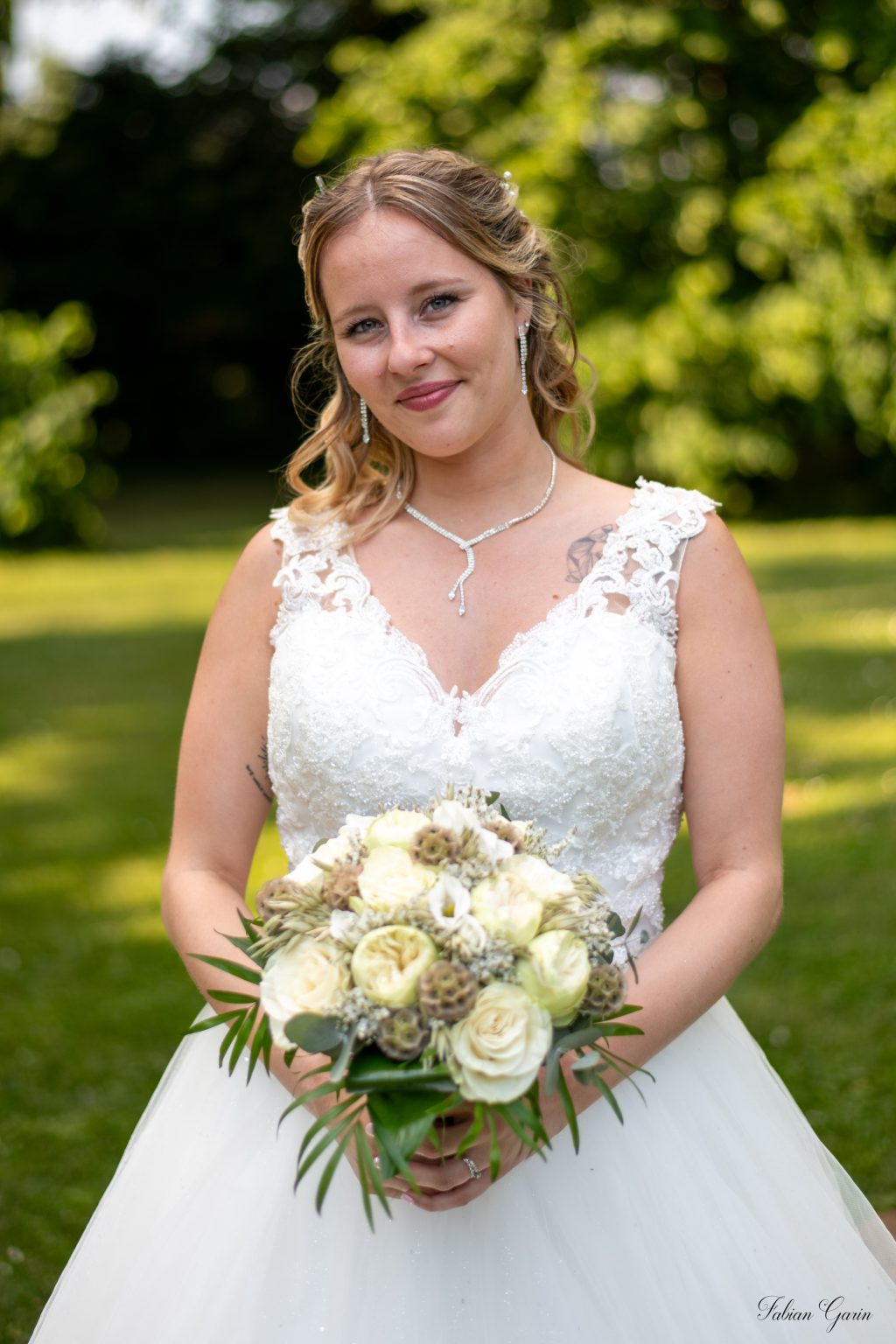 Photographe de mariage à Cambrai – Portrait d’Emy tenant son bouquet au château de la Motte Fénelon.