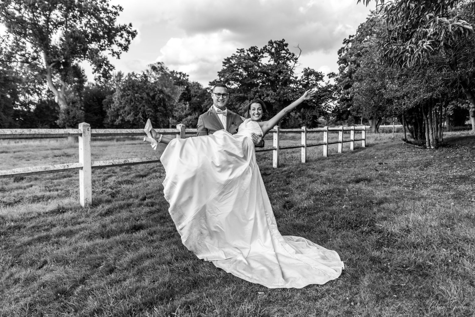 Maeva marche dans un parc en robe de mariée, vue de dos en noir et blanc