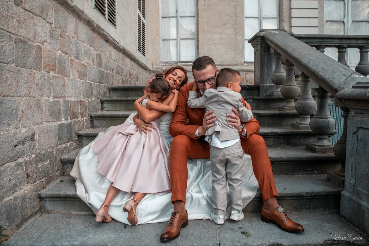 Maeva et ses demoiselles d'honneur rient ensemble sur un escalier, moments complices avant la cérémonie