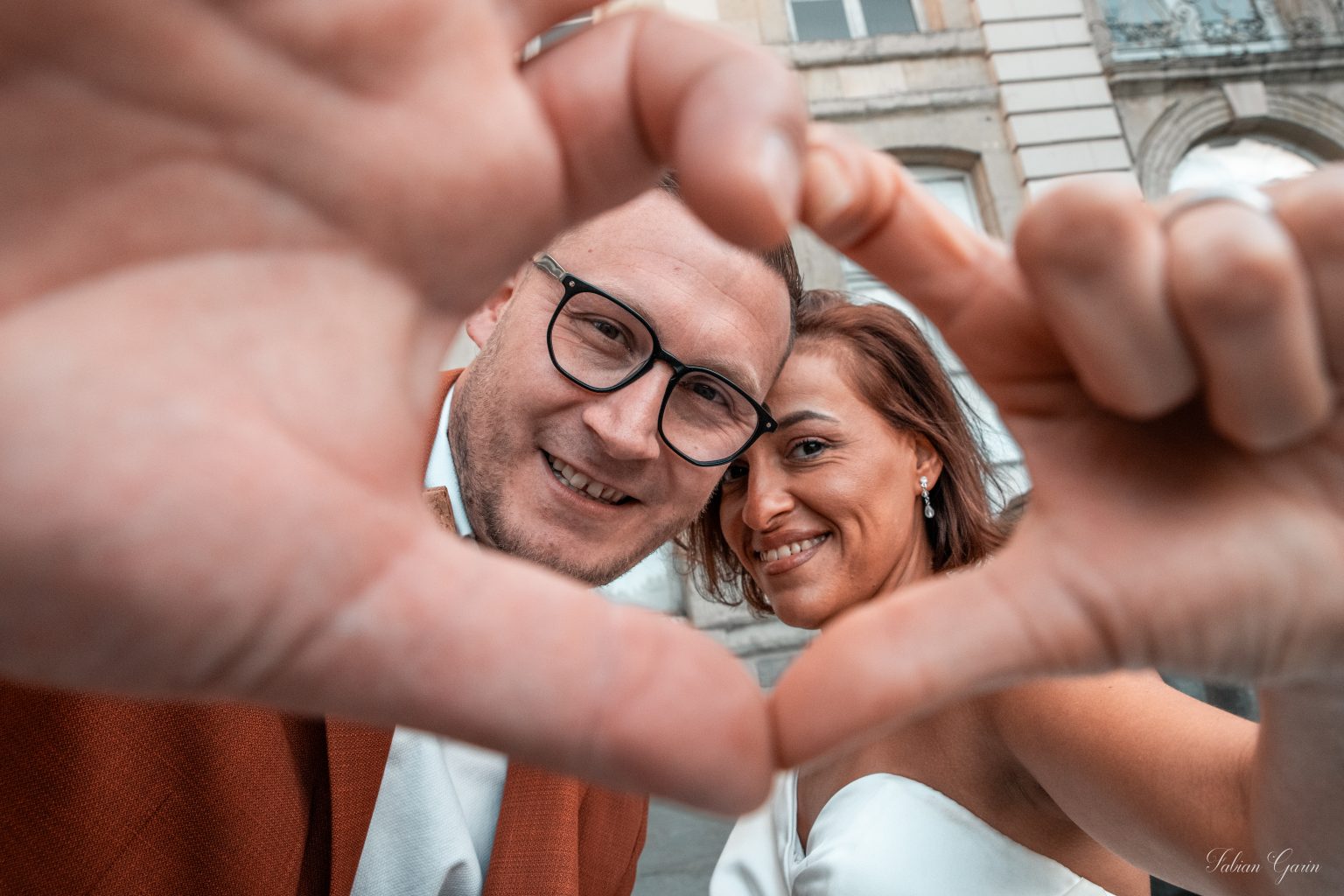 Photo rapprochée de plusieurs mains présentant les alliances du mariage
