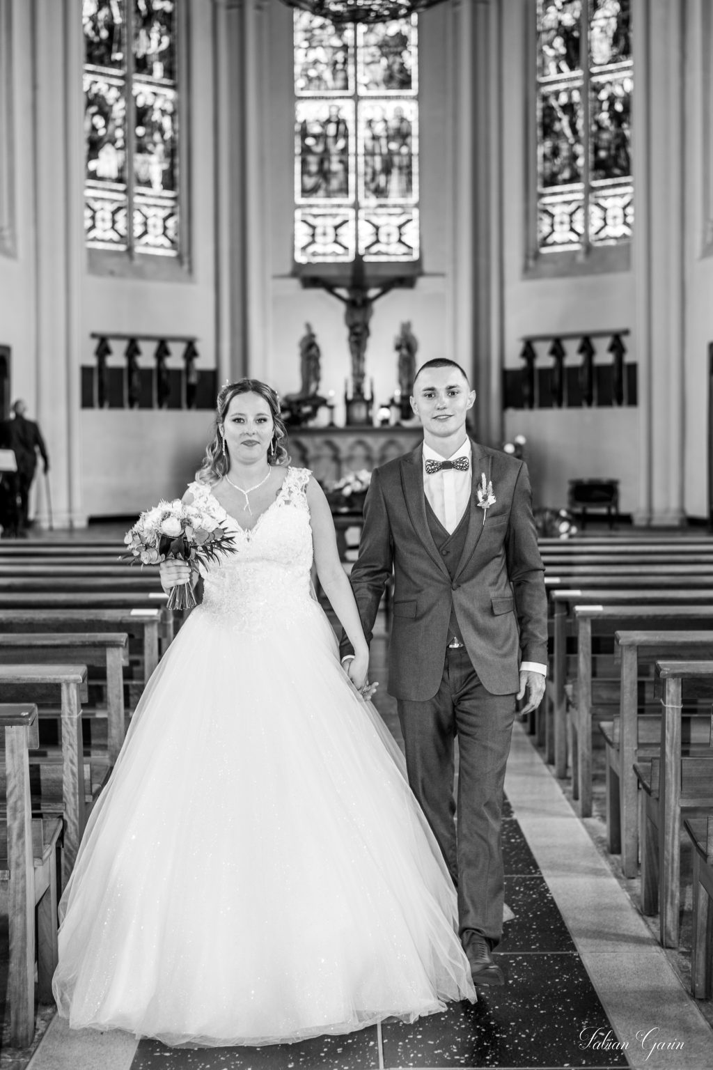 Photographe de mariage à Aniche – Emy marchant dans l’église lors de la cérémonie religieuse.